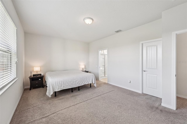 carpeted bedroom featuring ensuite bathroom