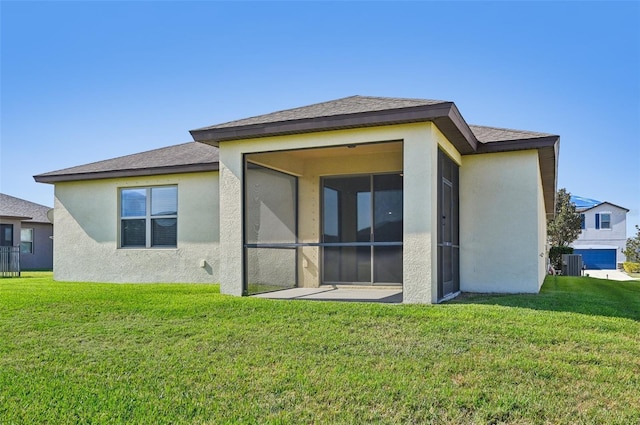 rear view of property featuring a sunroom, a yard, and central AC unit