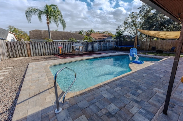 view of pool featuring a trampoline and a patio