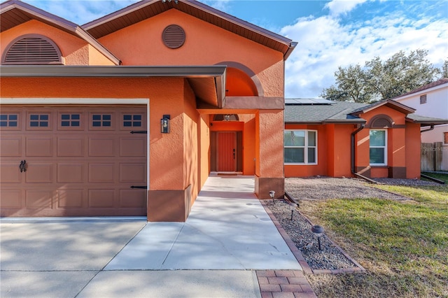 view of front of home with a garage and solar panels