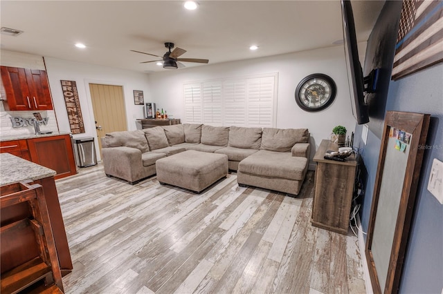 living room featuring ceiling fan and light wood-type flooring