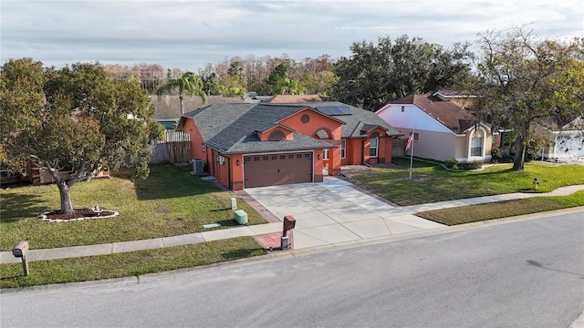 view of front of property featuring a garage, a front yard, central AC unit, and solar panels