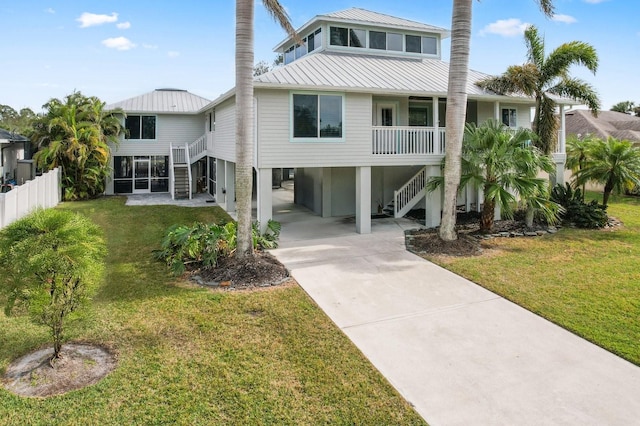 back of property with a lawn and a carport