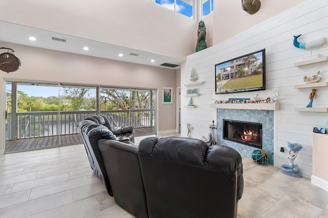 living room featuring a healthy amount of sunlight, a fireplace, and a high ceiling