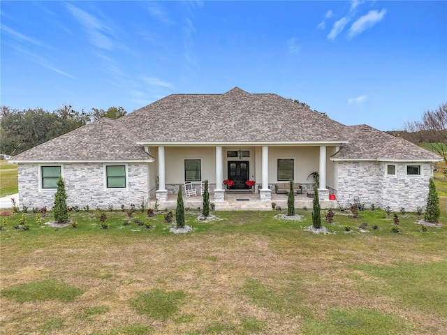 back of property featuring covered porch, a yard, and a patio