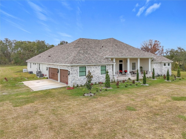 rear view of house with central AC, covered porch, a yard, and a garage