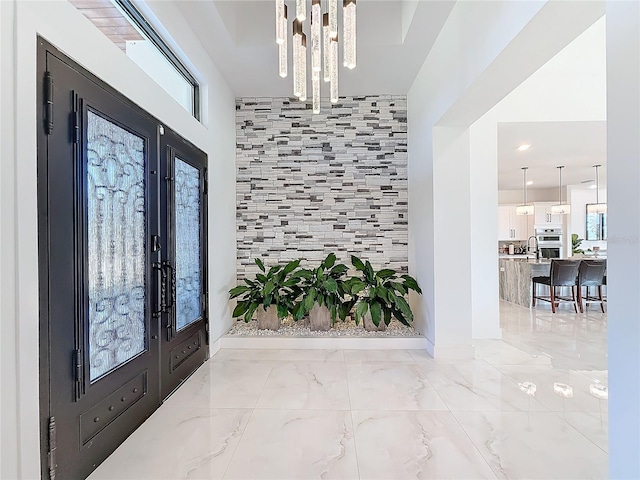 entrance foyer with sink, french doors, and an inviting chandelier