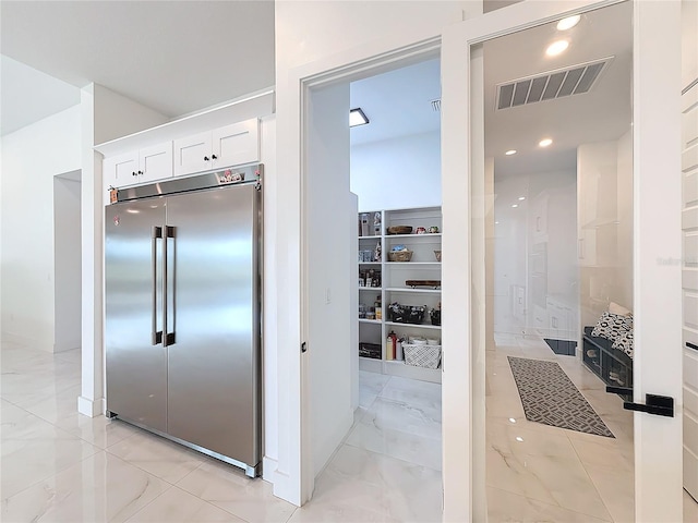 kitchen featuring white cabinetry and stainless steel built in refrigerator