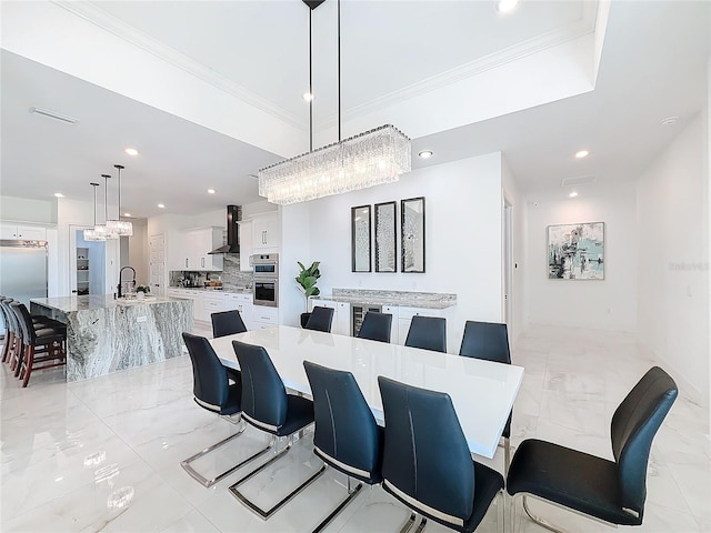 dining room featuring a notable chandelier, sink, and crown molding