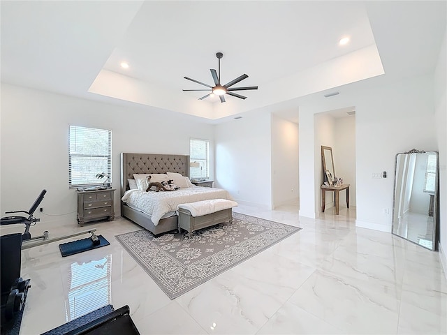 bedroom featuring ceiling fan and a tray ceiling