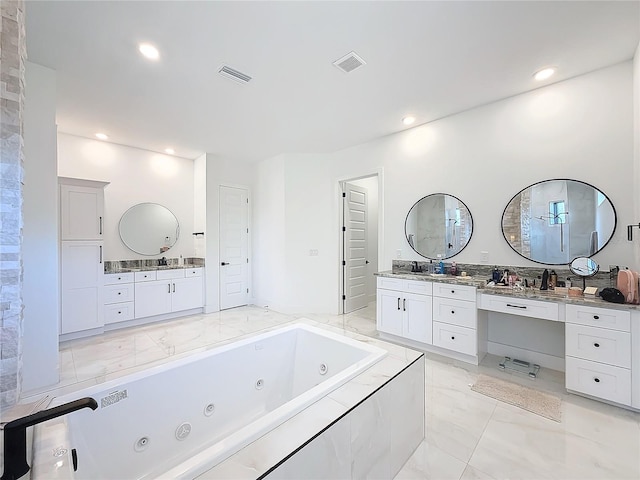 bathroom with vanity and tiled tub