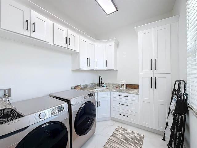 laundry room featuring cabinets, separate washer and dryer, and sink