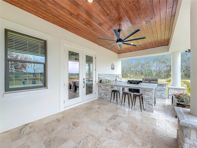 view of patio / terrace featuring an outdoor wet bar, ceiling fan, exterior kitchen, french doors, and area for grilling