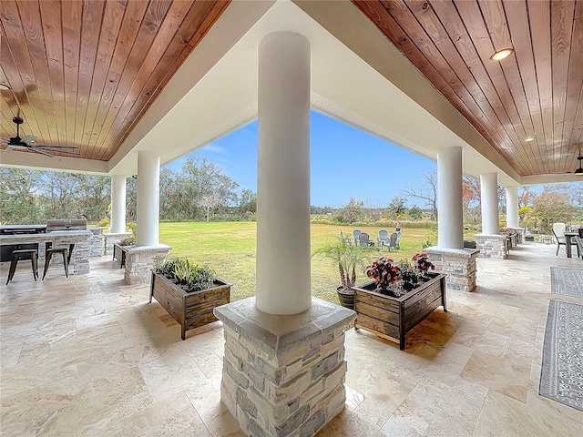 view of patio with exterior kitchen and a grill