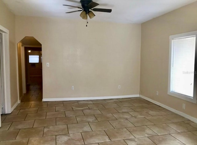 tiled spare room with ceiling fan