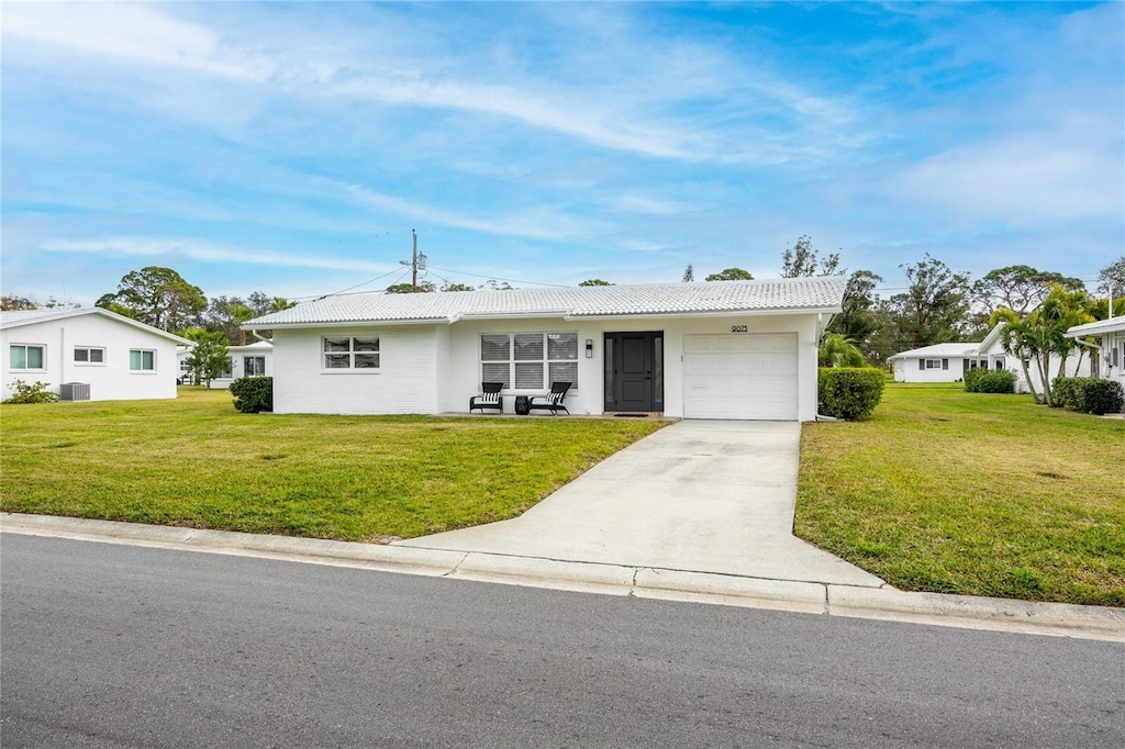 single story home with a front yard and a garage