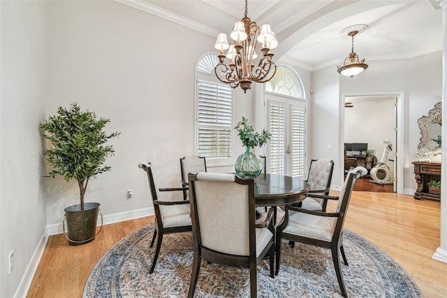 dining room with a chandelier, wood-type flooring, and ornamental molding