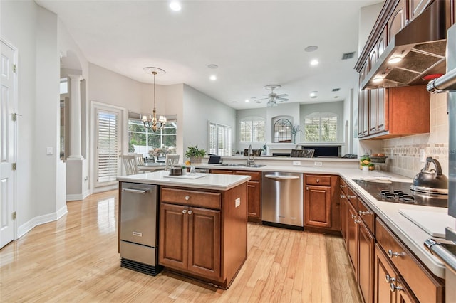 kitchen featuring ceiling fan with notable chandelier, kitchen peninsula, light wood-type flooring, stainless steel dishwasher, and black electric cooktop