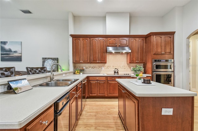 kitchen with stainless steel double oven, black electric stovetop, decorative backsplash, light wood-type flooring, and sink