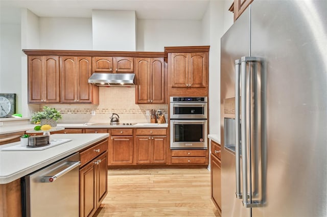 kitchen with decorative backsplash, light hardwood / wood-style floors, and stainless steel appliances