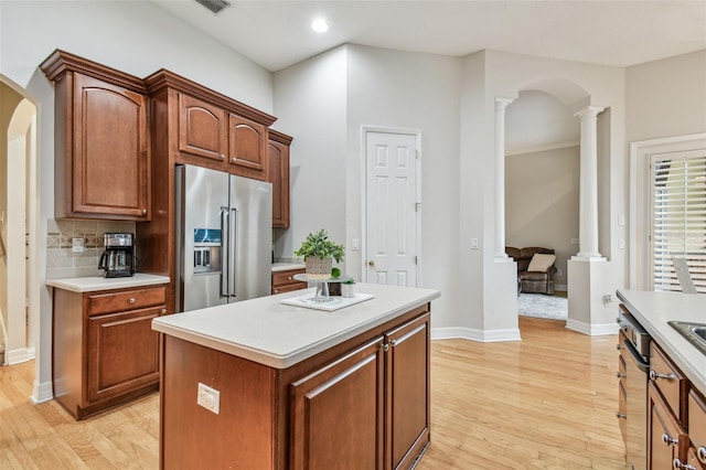 kitchen featuring light hardwood / wood-style floors, a kitchen island, high end refrigerator, and decorative columns