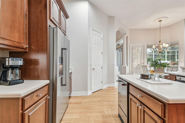 kitchen featuring hanging light fixtures, light wood-type flooring, an inviting chandelier, and high end fridge