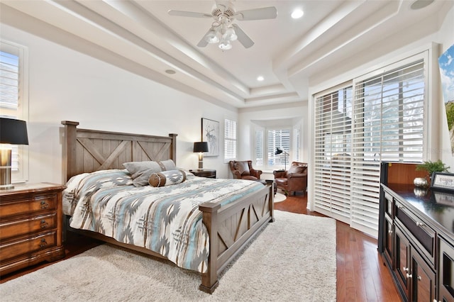 bedroom featuring a raised ceiling, ceiling fan, and dark wood-type flooring