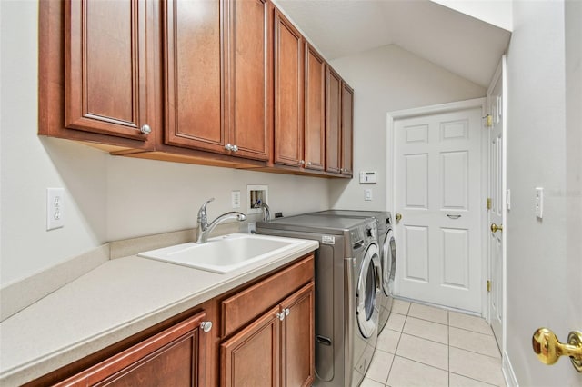 washroom with washer and dryer, light tile patterned flooring, sink, and cabinets