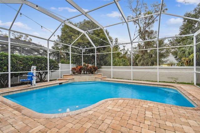 view of swimming pool with glass enclosure and a patio