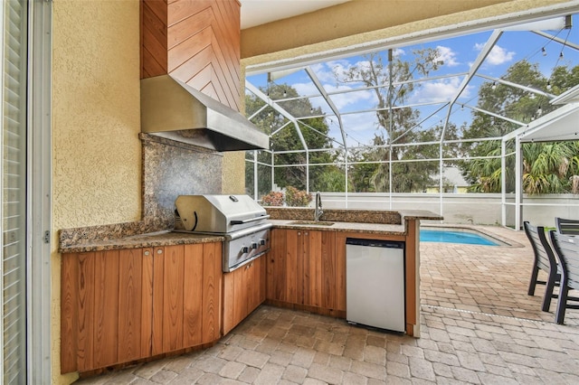 view of patio / terrace with grilling area, glass enclosure, an outdoor kitchen, and an outdoor wet bar