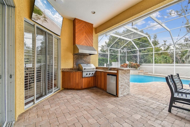 view of swimming pool featuring glass enclosure, a patio area, a grill, sink, and area for grilling