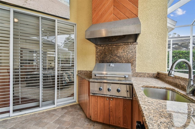 view of patio / terrace with exterior kitchen, sink, glass enclosure, and grilling area