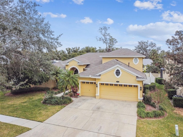 mediterranean / spanish home featuring a front yard and a garage