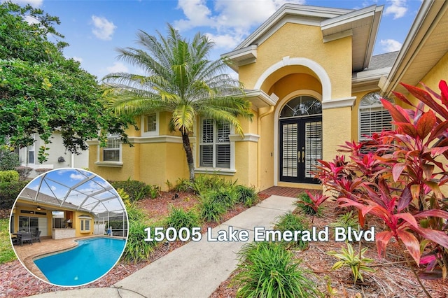 entrance to property with a patio area, french doors, an outdoor pool, and stucco siding