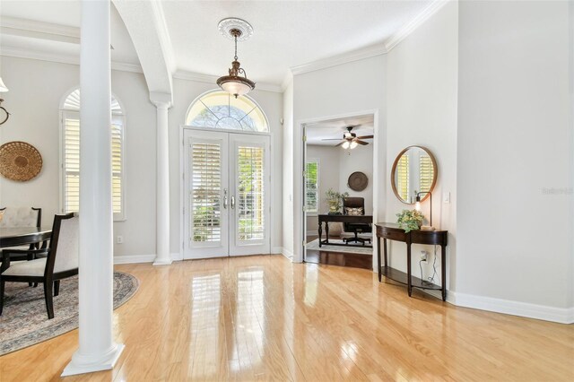 entrance foyer featuring light wood-style flooring, decorative columns, and baseboards