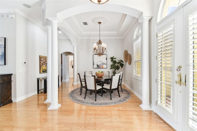 dining room with visible vents, light wood-type flooring, and decorative columns