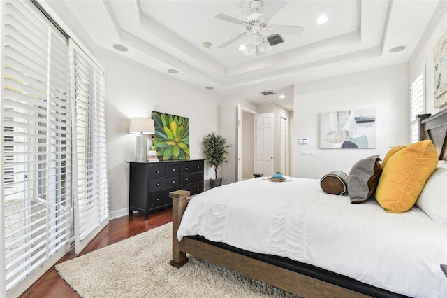 bedroom featuring visible vents, a ceiling fan, wood finished floors, recessed lighting, and a raised ceiling