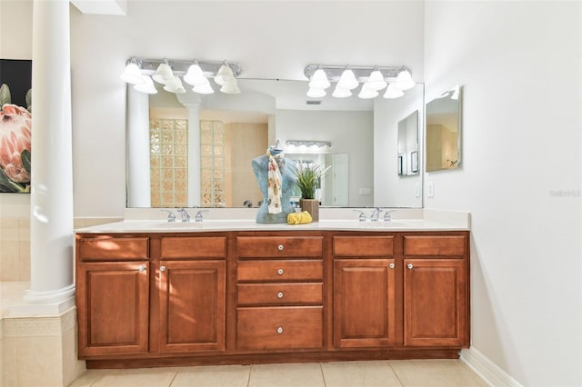 full bathroom with tile patterned flooring, double vanity, ornate columns, and a sink