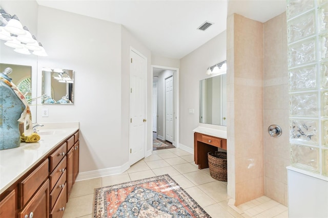 bathroom featuring visible vents, a walk in shower, baseboards, tile patterned floors, and vanity