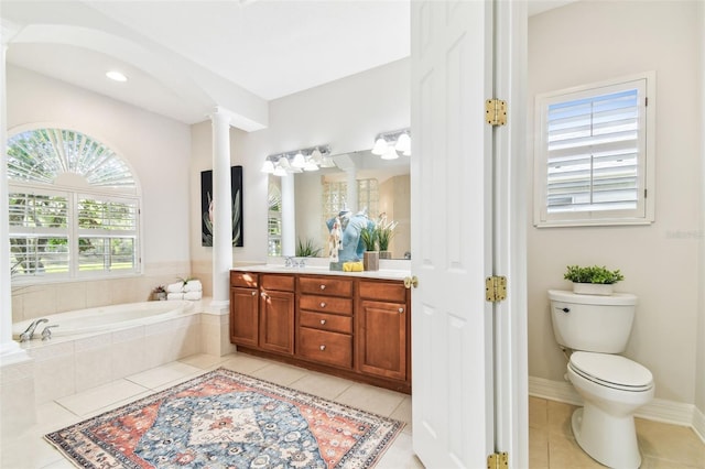 bathroom with tile patterned flooring, baseboards, toilet, a garden tub, and vanity