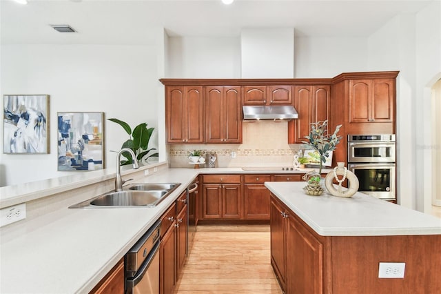 kitchen featuring visible vents, a sink, light countertops, appliances with stainless steel finishes, and under cabinet range hood