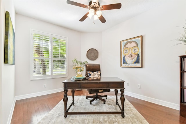 home office with a ceiling fan, baseboards, and wood finished floors