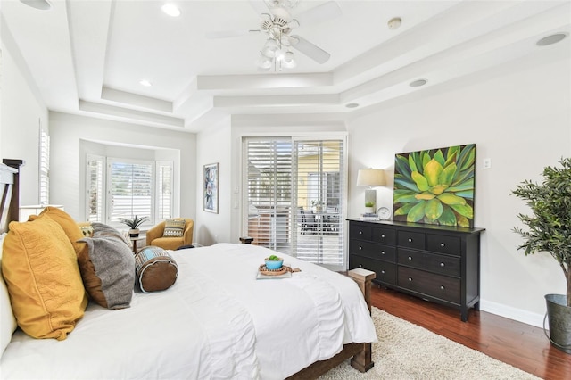 bedroom with baseboards, recessed lighting, access to exterior, dark wood-type flooring, and a raised ceiling