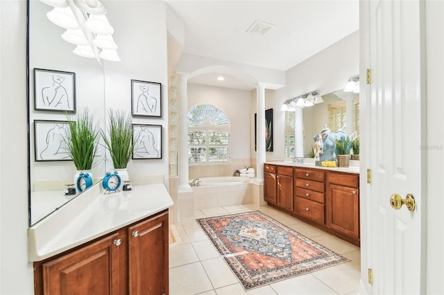 bathroom featuring tile patterned floors, a garden tub, vanity, and ornate columns