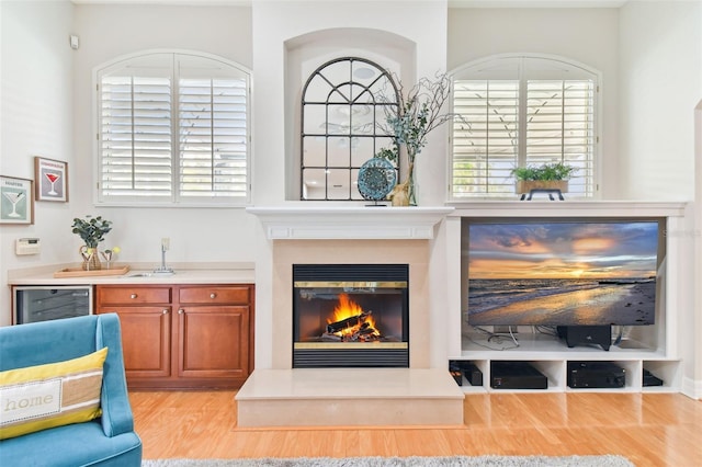 interior space with a glass covered fireplace and light wood-style floors