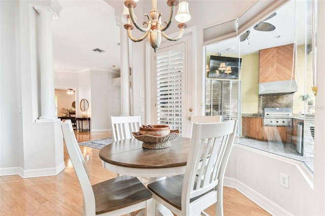 dining area featuring visible vents, baseboards, light wood-style floors, and ornate columns