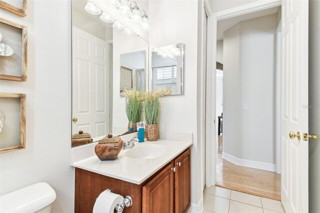 half bath featuring vanity, tile patterned floors, and toilet