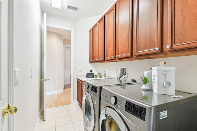 laundry area with visible vents, washer and dryer, cabinet space, light tile patterned floors, and baseboards