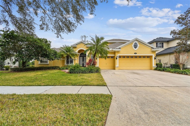 view of front of house with stucco siding, a garage, concrete driveway, and a front lawn