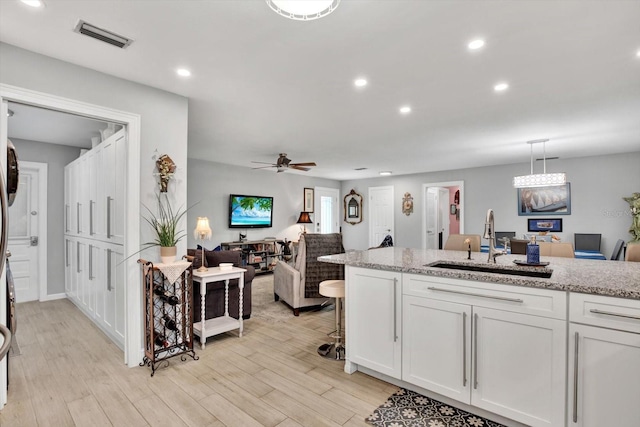 kitchen with light wood-style flooring, a sink, visible vents, and recessed lighting